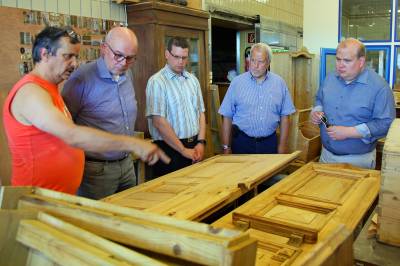 In der Schreinerei erläutert Werner Parker (links) Stadtverordnetenvorsteher Michael Refflinghaus, Frank Jungk, Klaus-Dieter Behlen und Bürgermeister Stephan Paule (von links nach rechts) die Restaurierung einer alten Haustür.